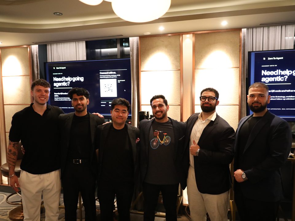 Six people from the event standing together in front of Zero to Agent screens.